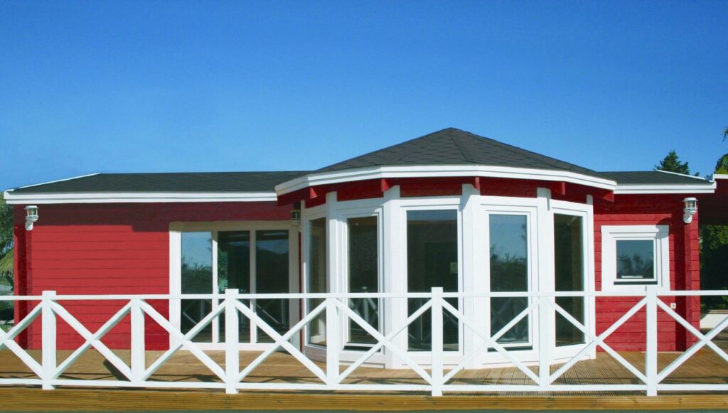une maison rouge et blanche avec une clôture blanche