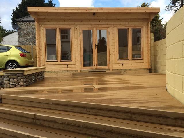 un bâtiment en bois avec des escaliers et une voiture garée à l'arrière