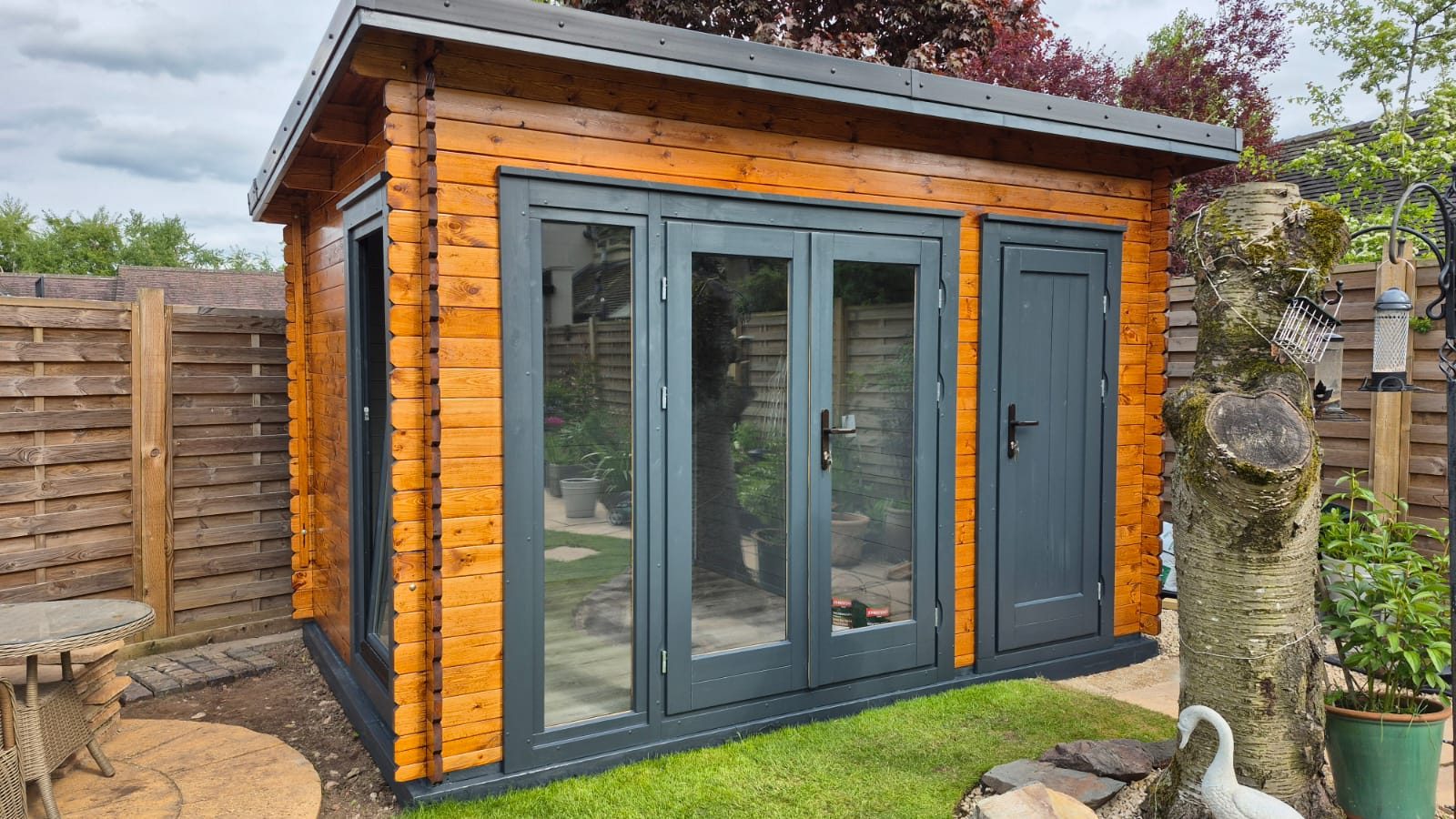 Stained garden office with corner glazing and dark frames