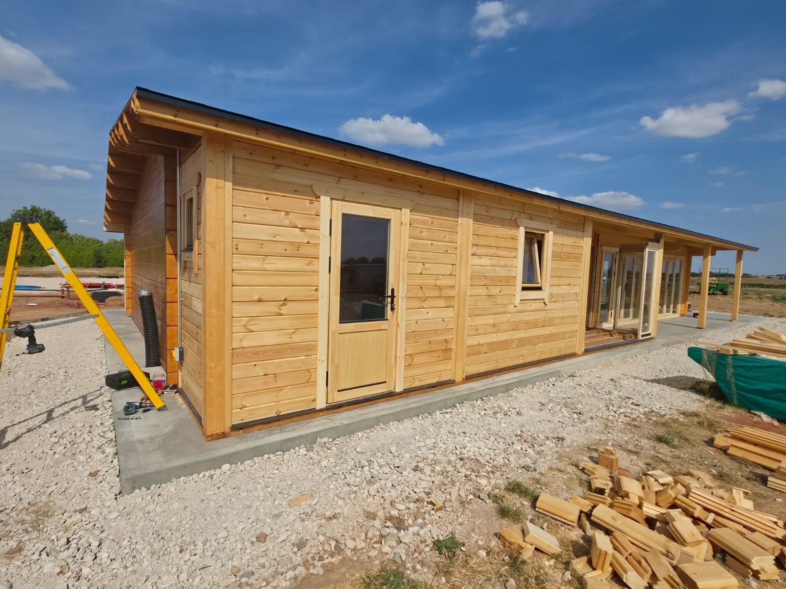 Single-storey timber building with double doors and a veranda, photographed on a delivered order