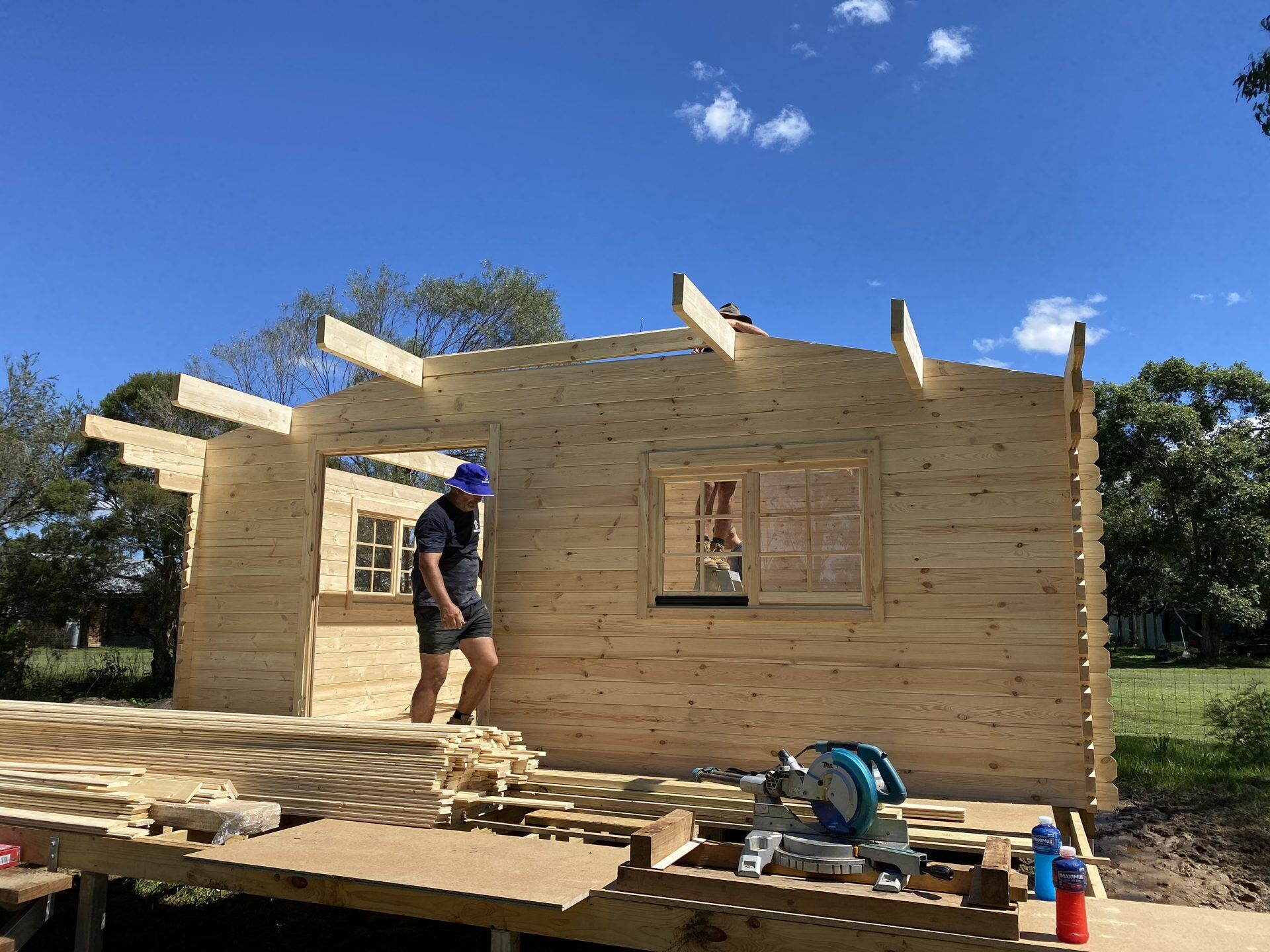 Gable logs and purlins in place on a solid log cabin kit during assembly