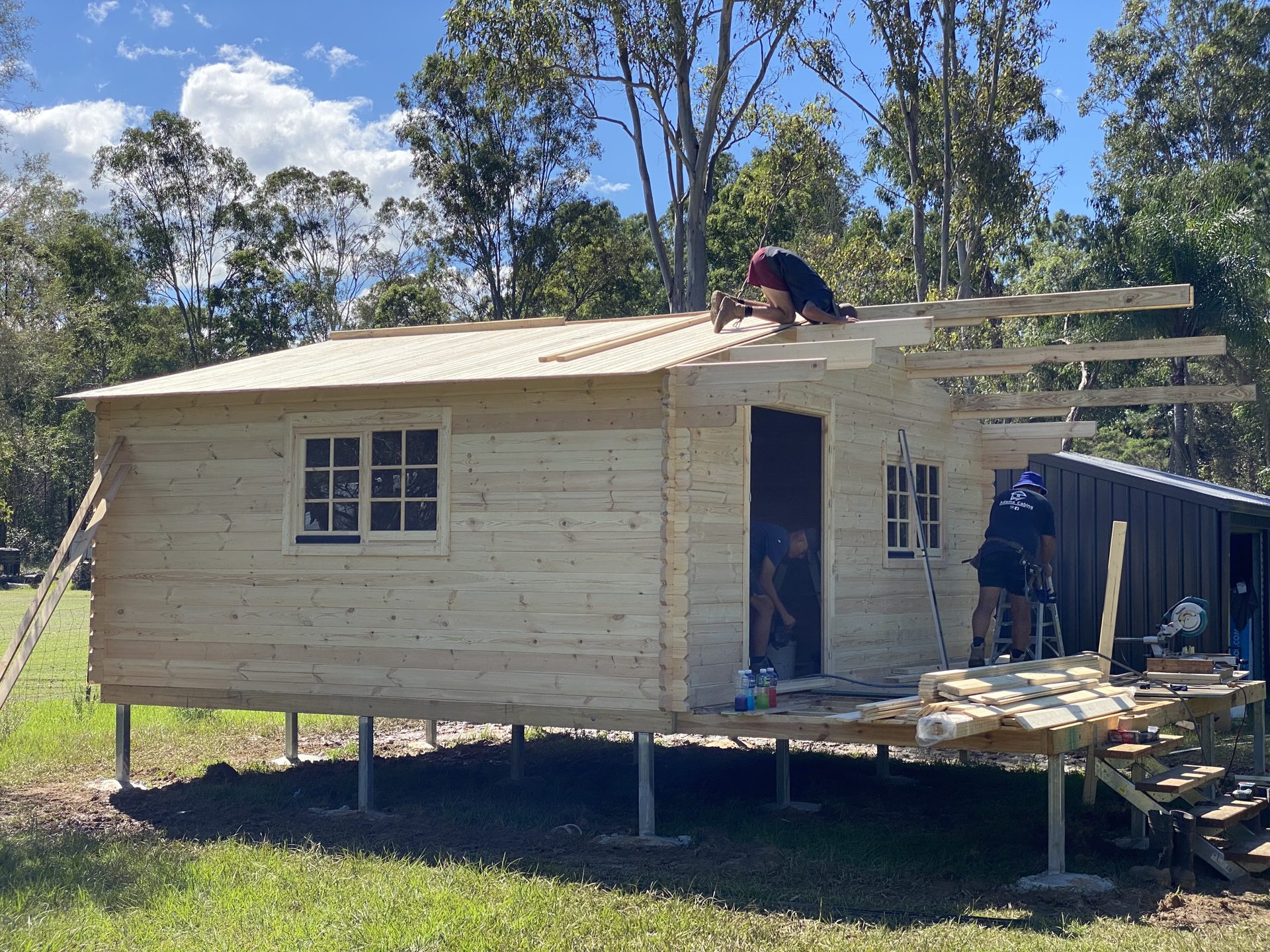 Roof boards being fixed on a log cabin kit near the end of assembly